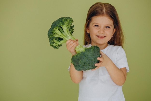 Klein meisje geïsoleerd met groene rauwe broccoli