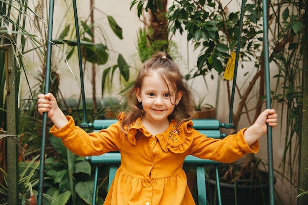 Klein meisje in de botanische tuin Close-up portret van een kind met donker haar gezondheid schoonheid concept