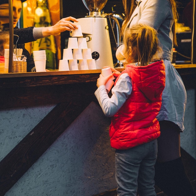 Klein meisje in de buurt van balie op straatvoedselfestival