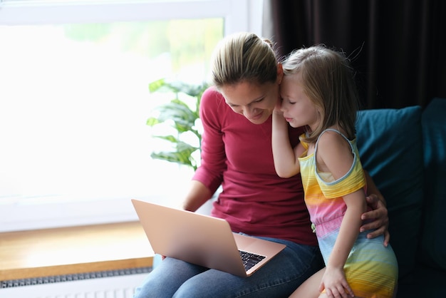 Klein meisje in de kamer praat met haar moeder met een laptop