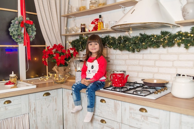 klein meisje in de keuken met kerstmis