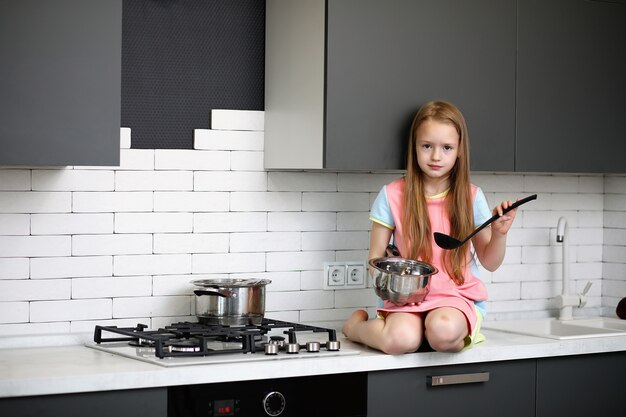 Klein meisje in de keuken poseren voor de camera