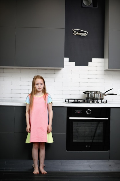 Klein meisje in de keuken poseren voor de camera