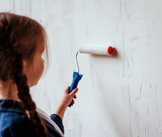 Foto klein meisje in een kamer met een houten muur. bouw