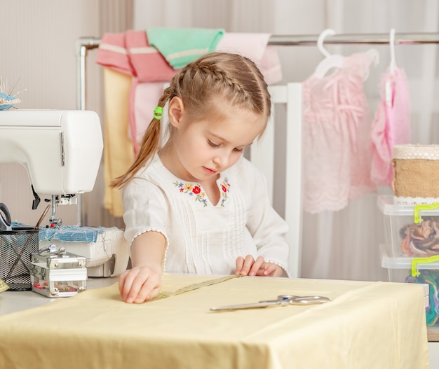 Klein meisje in een naaiatelier