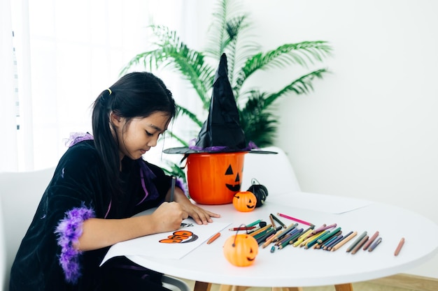 Klein meisje in halloween-kostuum jackolantern maken