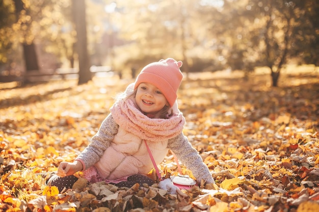 Klein meisje in herfstbladeren