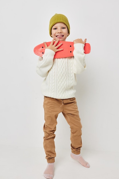 Klein meisje in hoeden met een skateboard in hun handen onveranderde kinderjaren