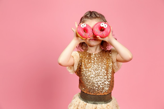 Klein meisje in jurk met donuts