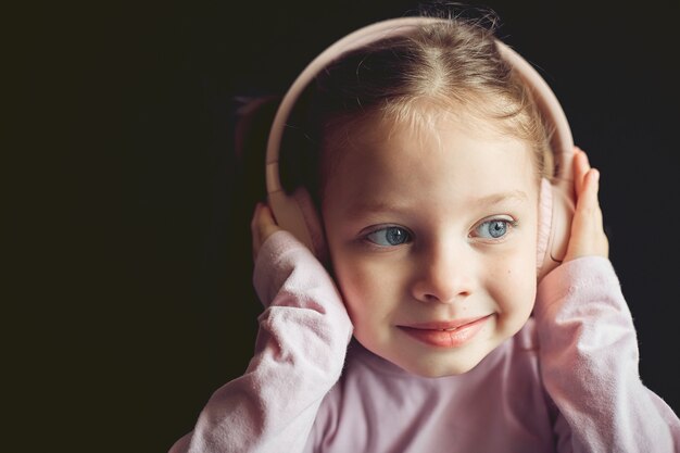 klein meisje in koptelefoon luisteren naar muziek, portret van een blanke kind