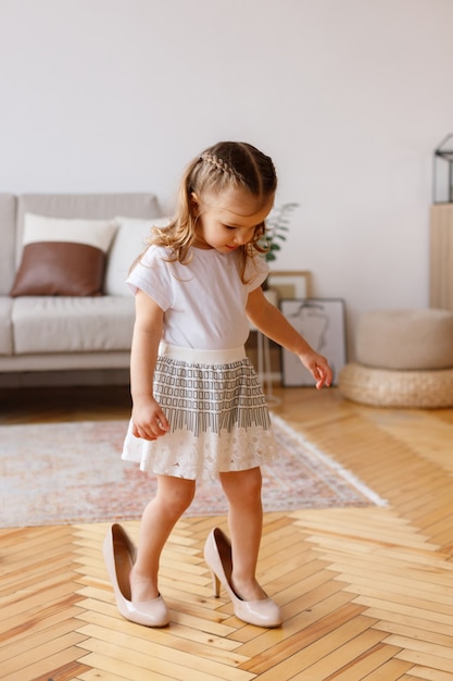 Klein meisje in moeders schoenen thuis