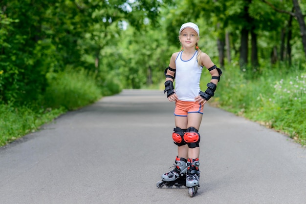 Klein meisje in rolschaatsen in een park