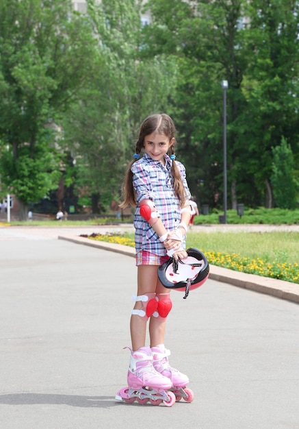 Klein meisje in rolschaatsen in het park