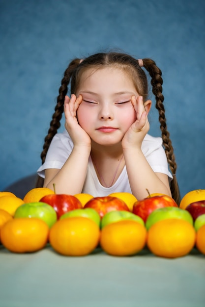 Klein meisje in wit T-shirt houdt van fruit