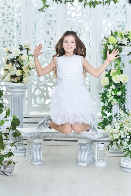 Klein meisje in witte jurk springen