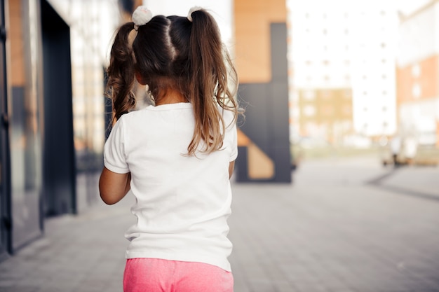 Klein meisje in witte t-shirtruimte voor uw logo of ontwerpmodel om af te drukken