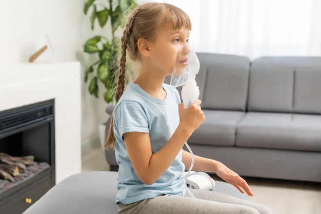 Klein meisje inhaleren met vernevelaar thuis. kind astma-inhalator inademing vernevelaar stoom ziek hoest concept.