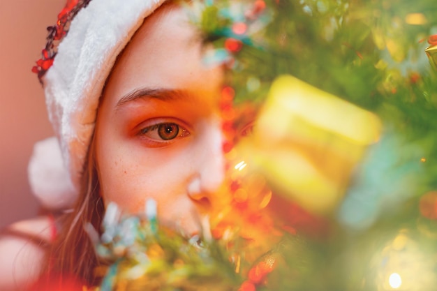 Klein meisje kijkt naar het kerstboom Feestelijk nieuwjaarsconcept