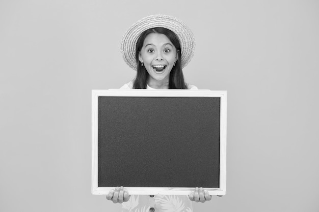 Klein meisje kind draagt zomerstijl hoed houd schoolbord informatie kopieer ruimte avond show concept