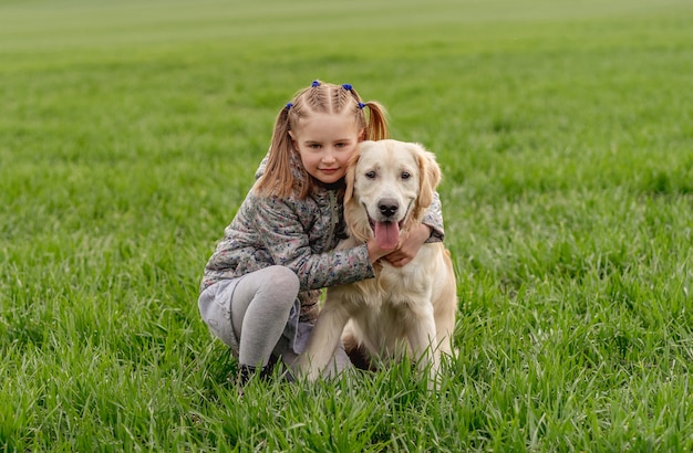 Klein meisje knuffelen hond op veld