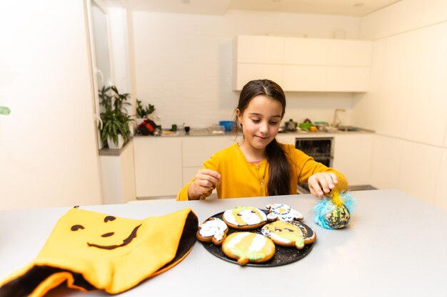 Klein meisje koekjes eten op een halloween-feest.