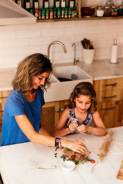 Klein meisje koken met haar moeder in de keuken. baby chef-kok concept.