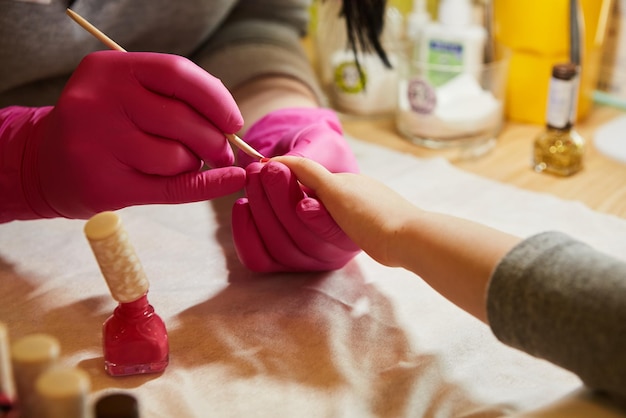 Klein meisje krijgt manicure in schoonheidssalon close-up