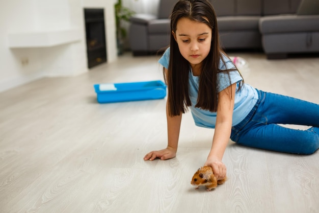 Klein meisje lacht en kijkt naar haar hamster