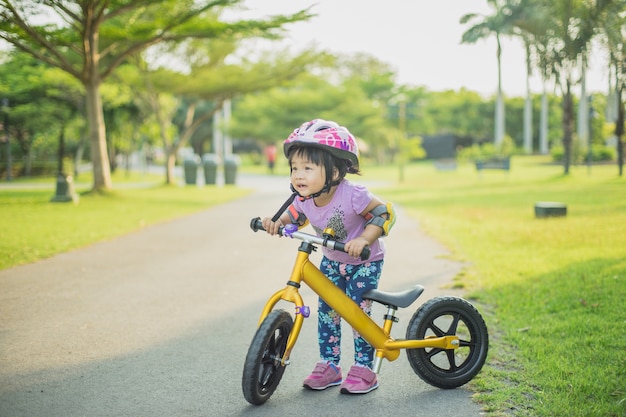 Klein meisje leert om te fietsen in het park