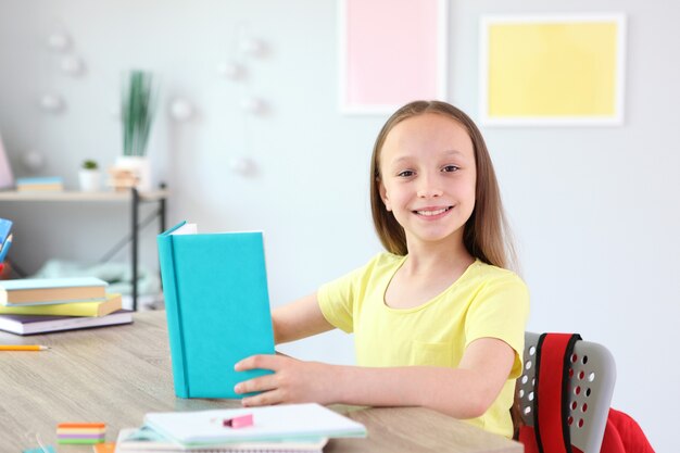 Klein meisje leest thuis een boek