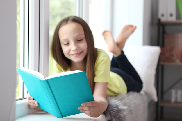 Klein meisje leest thuis een boek