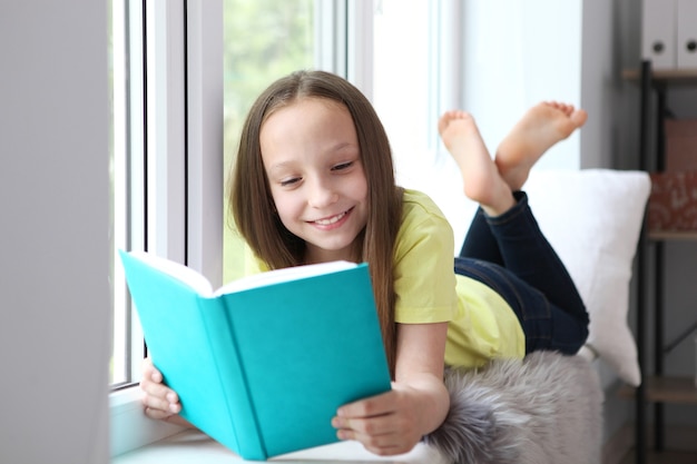 Klein meisje leest thuis een boek