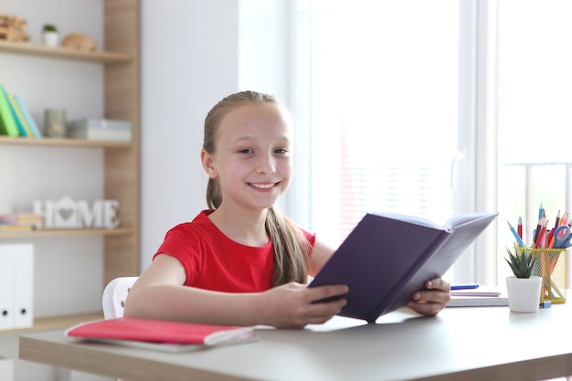 Klein meisje leest thuis een boek