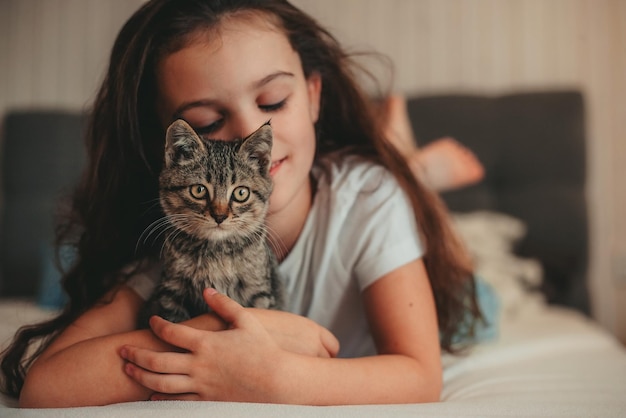 Foto klein meisje liggend in bed en knuffel de kitten