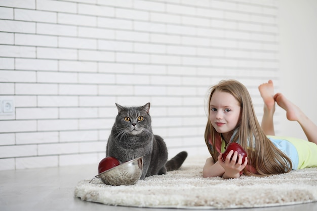 Klein meisje ligt op de grond en eet een appel