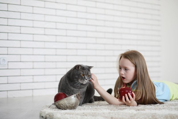 Klein meisje ligt op de grond en eet een appel