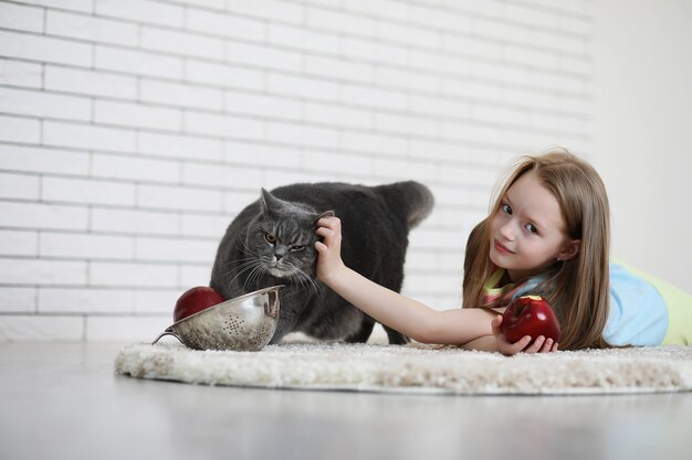 klein meisje ligt op de grond en eet een appel