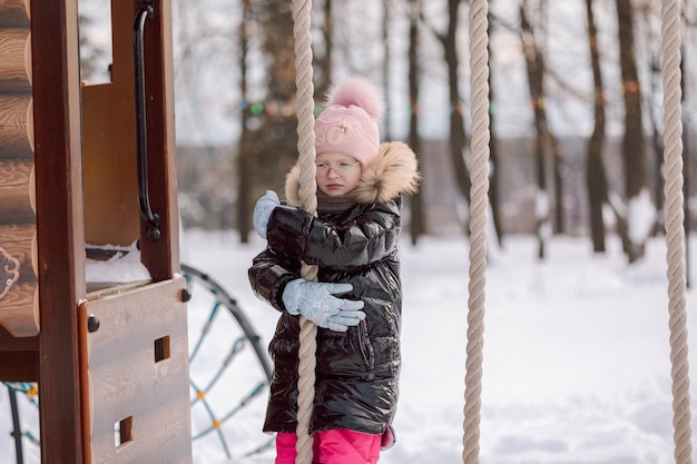 Klein meisje loopt buiten op besneeuwde winterdag in