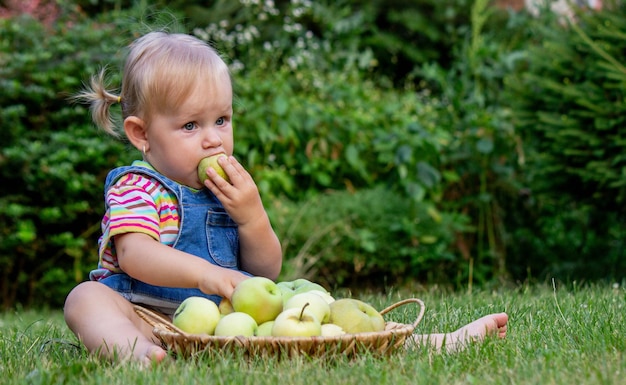 klein meisje met appels in de tuin