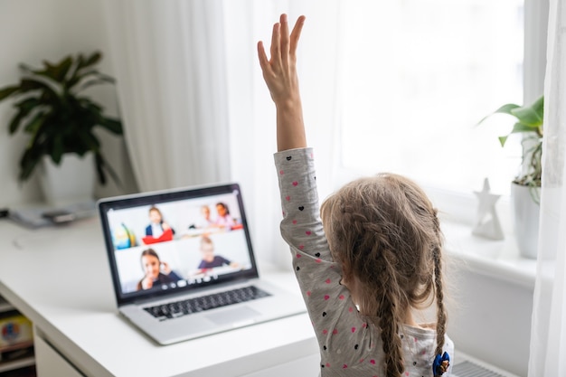 Klein meisje met behulp van videochat op laptop thuis. Ruimte voor tekst