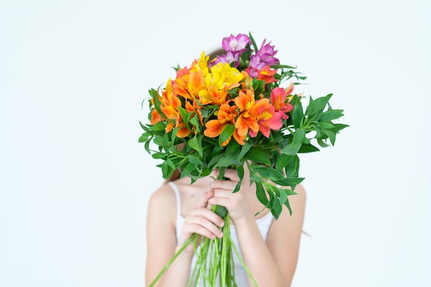 Klein meisje met een bloemboeket cadeau teder bloemen alstroemeria arrangement voor moeders of vrouwendag