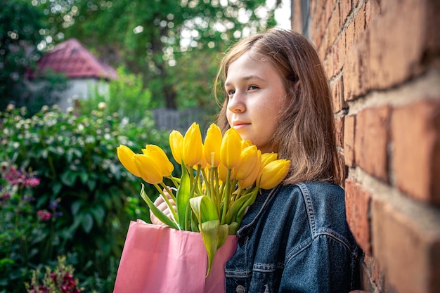 Klein meisje met een boeket gele tulpen