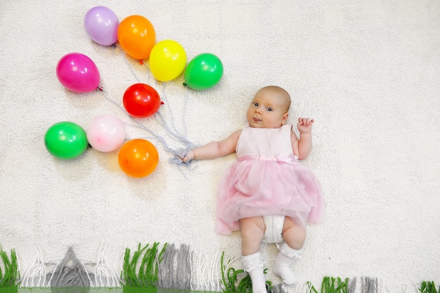 Klein meisje met een bos ballonnen en een vliegshow