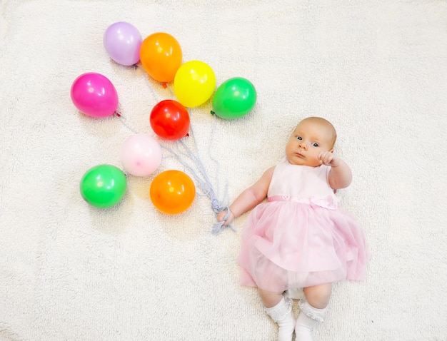 Klein meisje met een bos ballonnen en een vliegshow