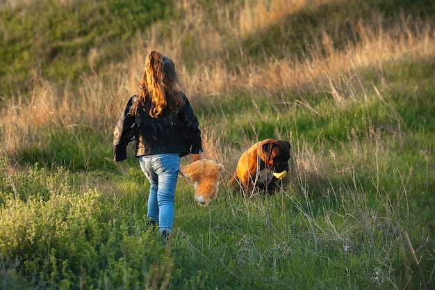 klein meisje met een speeltje in haar handen op een wandeling met een hond