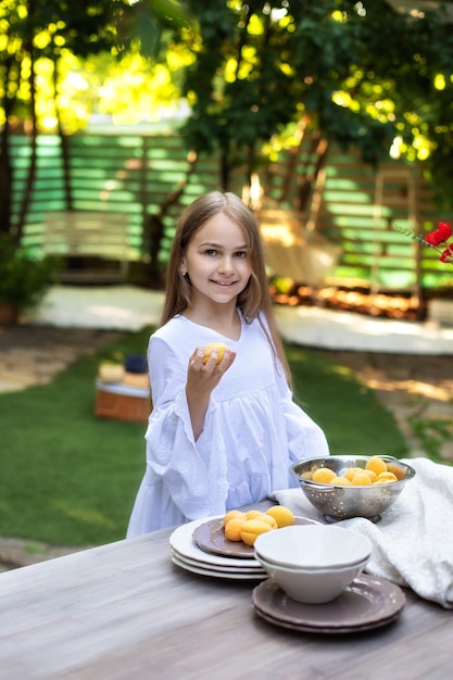 Klein meisje met fruit in een vergiet op tafel en ontbijt koken in de tuin zomer in de achtertuin