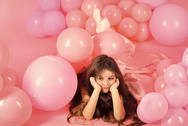 Klein meisje met lang haar in roze ballonnen klein meisje gelukkige jeugd roze verjaardagsballons