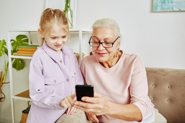 Klein meisje met oma thuis