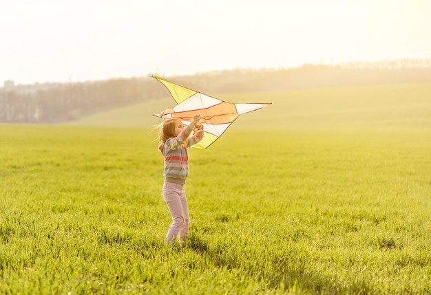 Klein meisje met vliegende kite