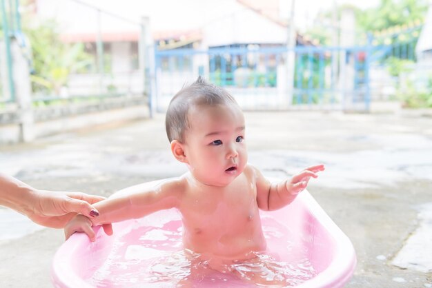 Klein meisje neemt een bad op homeasian baby shower timeThailand mensen